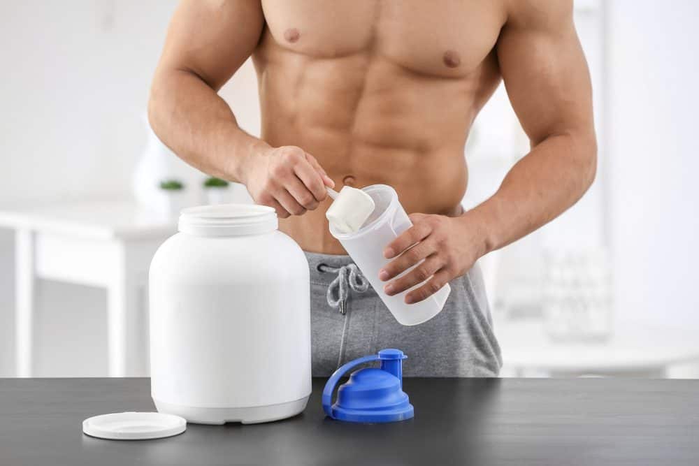 Young sporty man preparing protein shake