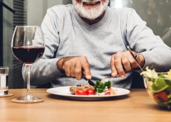 An older man starting to eat a meal.