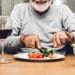 An older man starting to eat a meal.