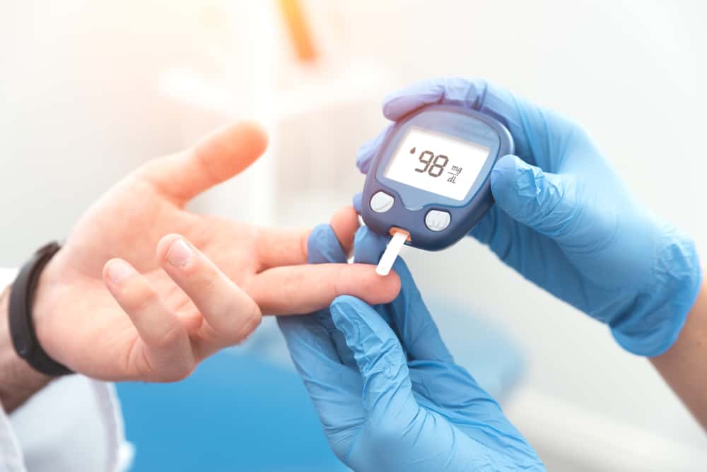 A closeup of a doctor testing someone with a diabetes monitor.