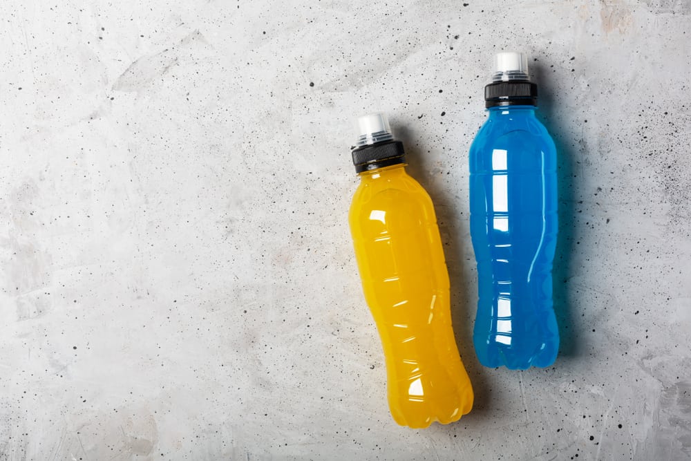 A closeup of some bottles of sports drinks, which are blue and yellow.