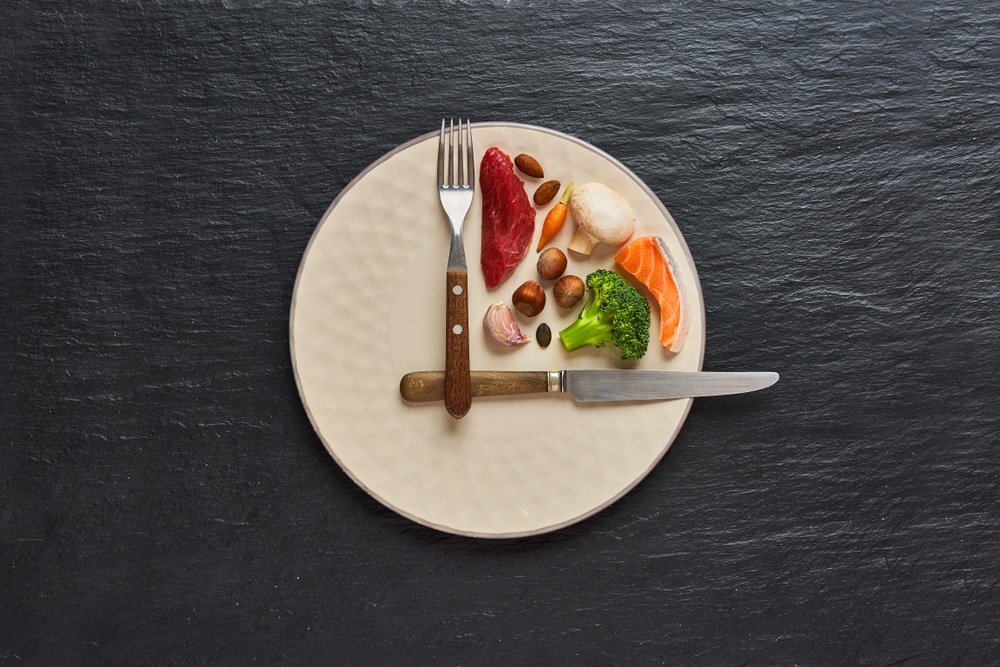 A plate, utensils, and food arranged like a clock.
