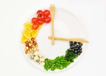 A plate with food and utensils arranged like a clock.