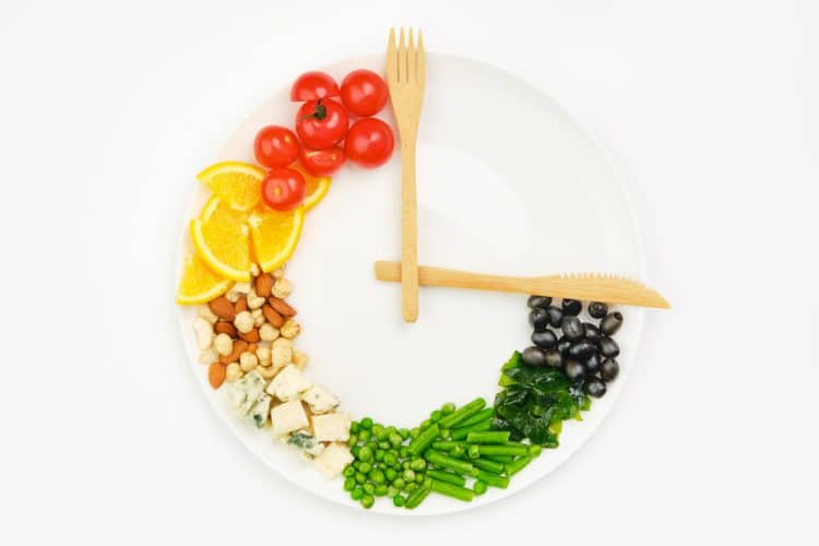A plate with food and utensils arranged like a clock.