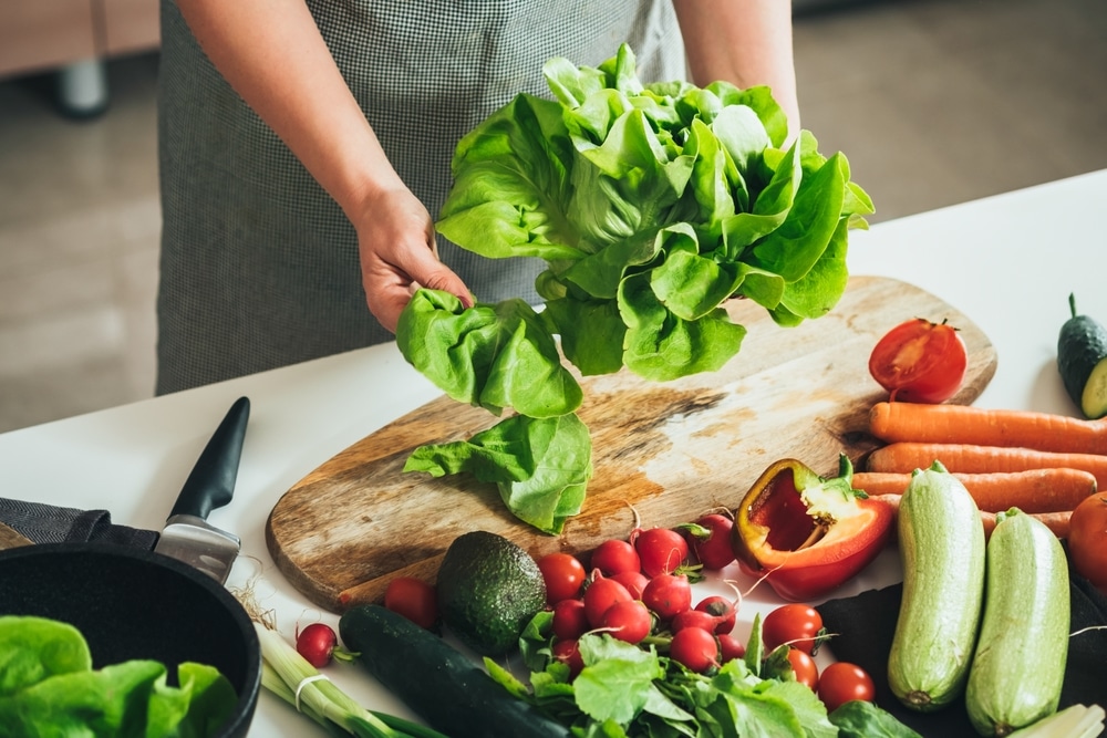 A woman preparing an assortment of vegetables.