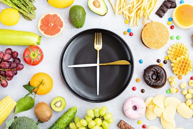 A plate and utensils arranged like a clock with food items surrounding them.