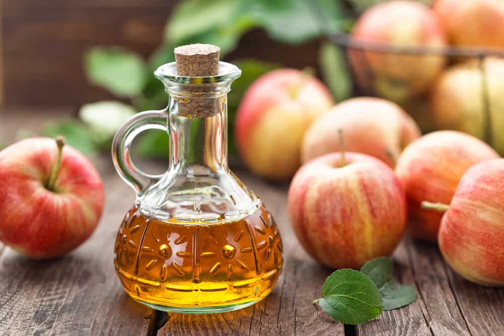 A closeup of a container of apple cider vinegar.